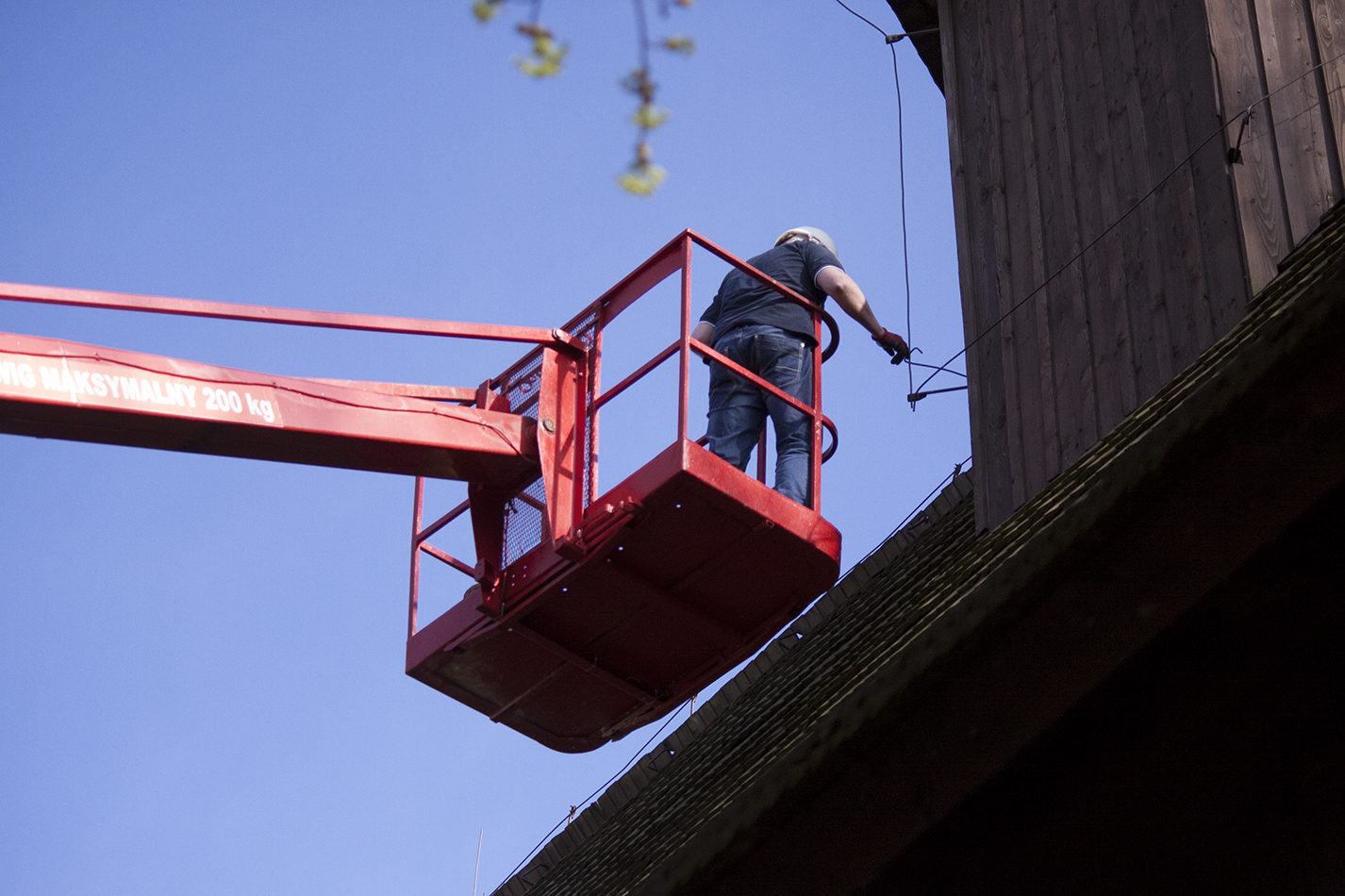 Pan Wojciech Węgrzyn podczas naprawy odgromnika na dachu drewnianego kościółka pw św. Jadwigi w Rybnicy Leśnej. Rynica Leśna, kwiecień 2015. fot. Patrycja Szuman