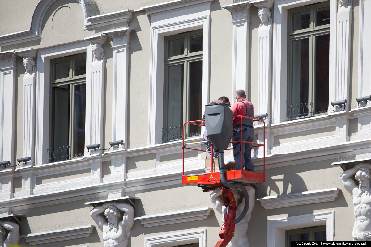 Robotnicy montujący oświetlenie na fasadzie frontowej budynku Biblioteki pod Atlantami w Rynku. Wałbrzych, czerwiec 2015. Fot. Jacek Zych